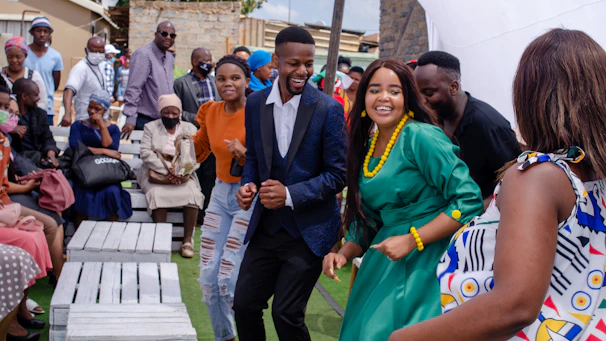 A joyful crowd dancing and sharing food at an outdoor multicultural festival.