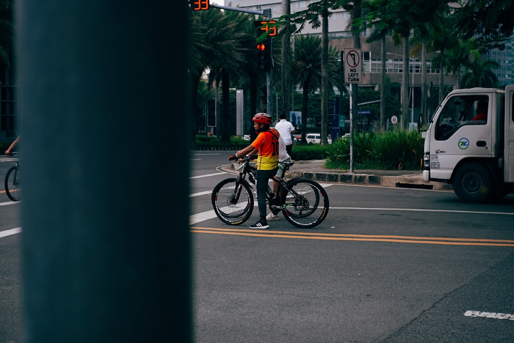 a man riding a bike down a street next to a traffic light