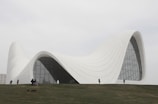 a large white building sitting on top of a lush green hillside