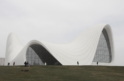 a large white building sitting on top of a lush green hillside