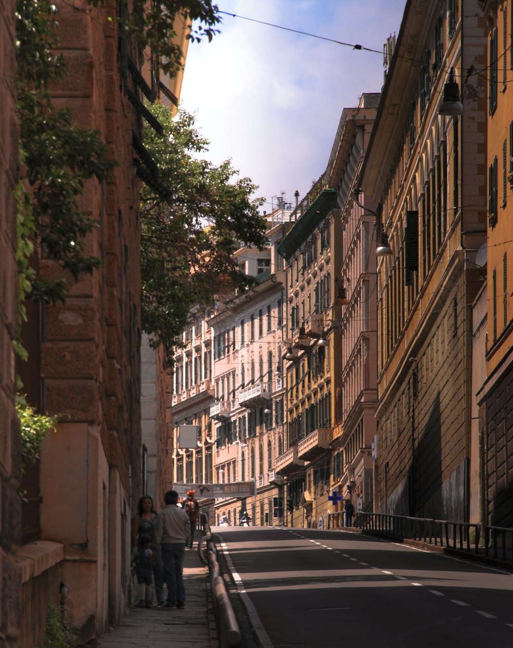 a group of people walking down a street next to tall buildings