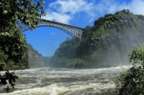 a bridge over a river with a waterfall below