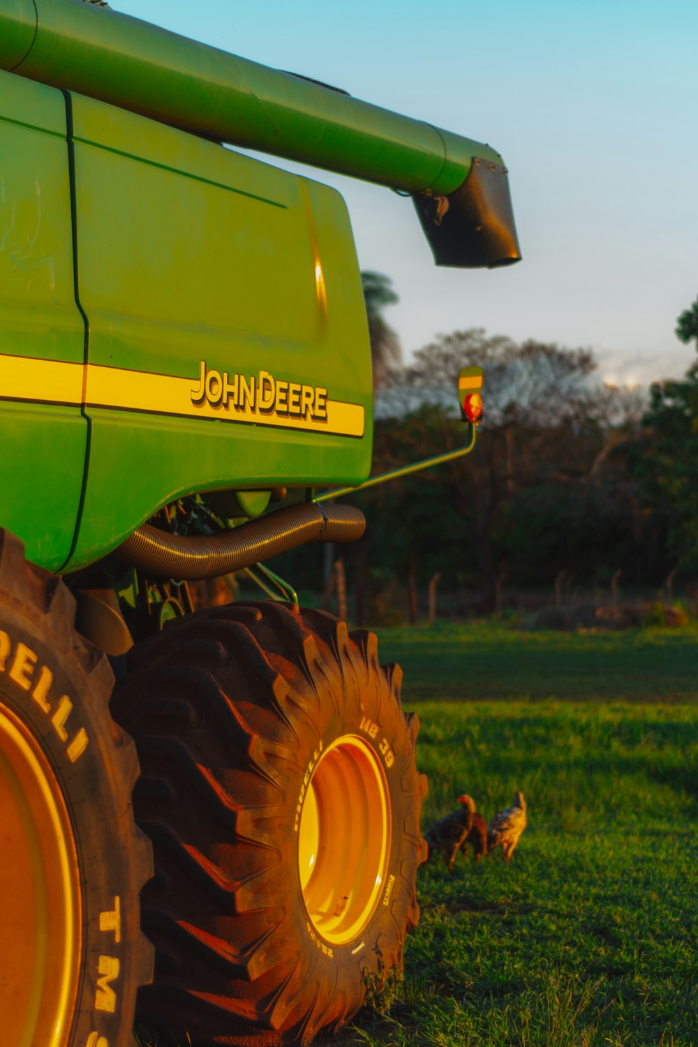 a large green tractor parked on top of a lush green field