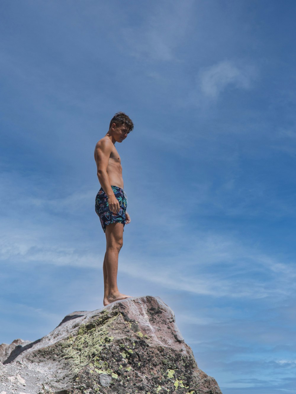 Ein junger Mann steht auf einem großen Felsen