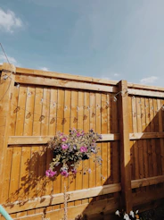 a wooden fence with flowers growing on it