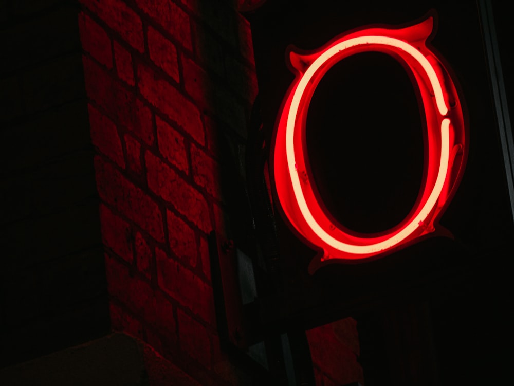 a close up of a neon sign on a brick wall