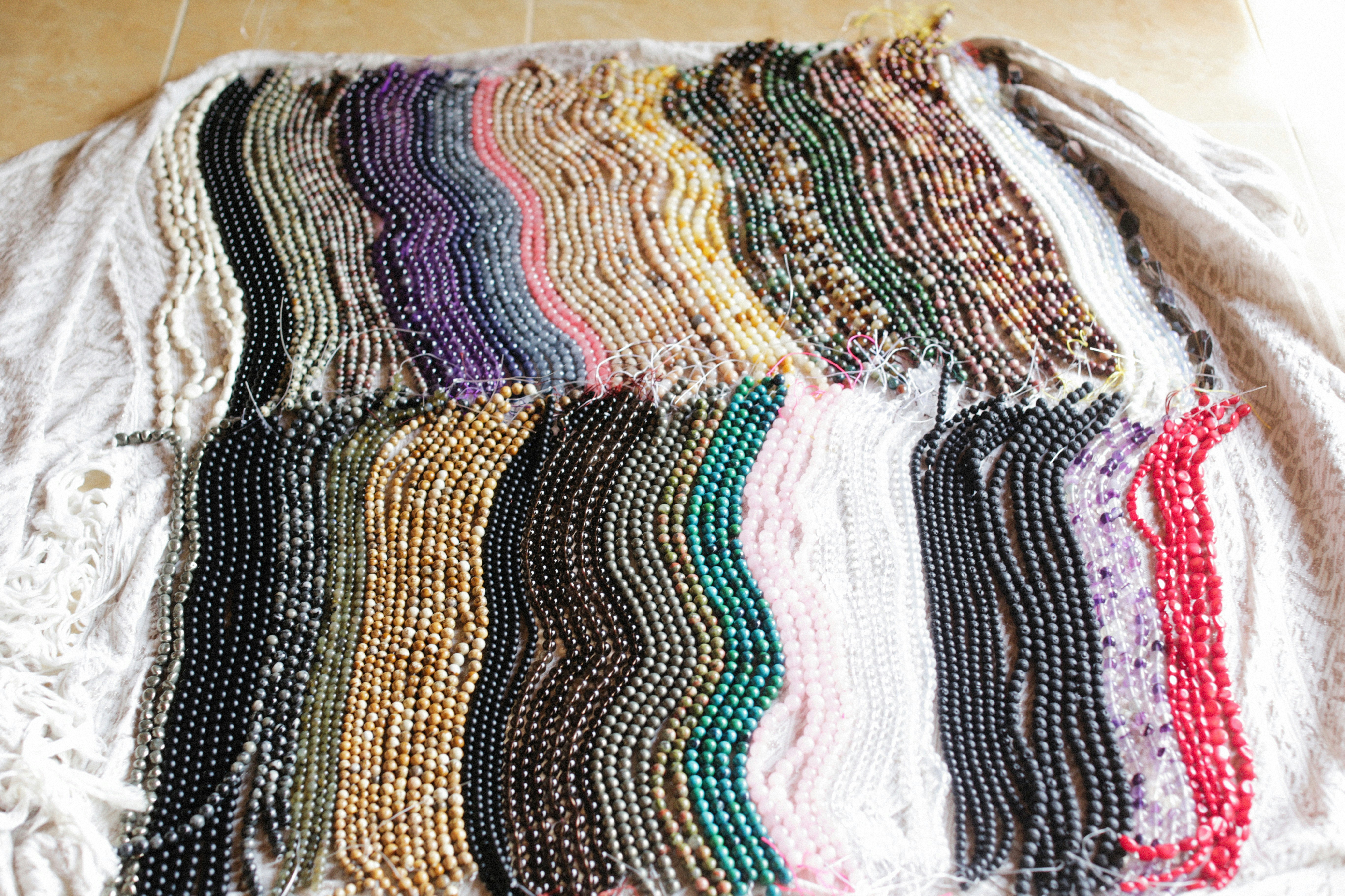 Beads arranged on a grey flocked U-channel bead board ready for stringing