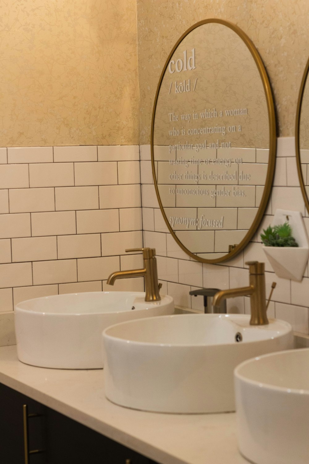 a couple of white sinks sitting under a mirror