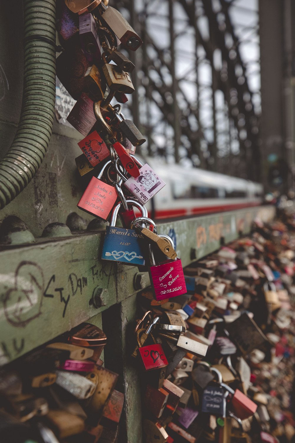 ein Bündel Vorhängeschlösser, die an einer Brücke befestigt sind