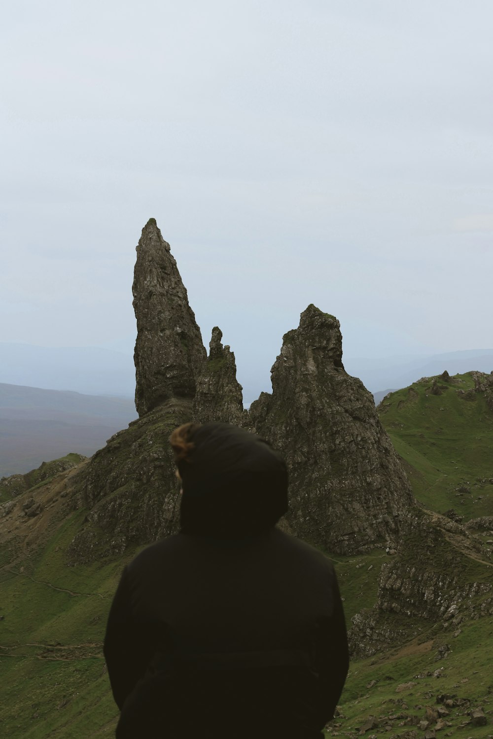 a person standing on top of a green hill