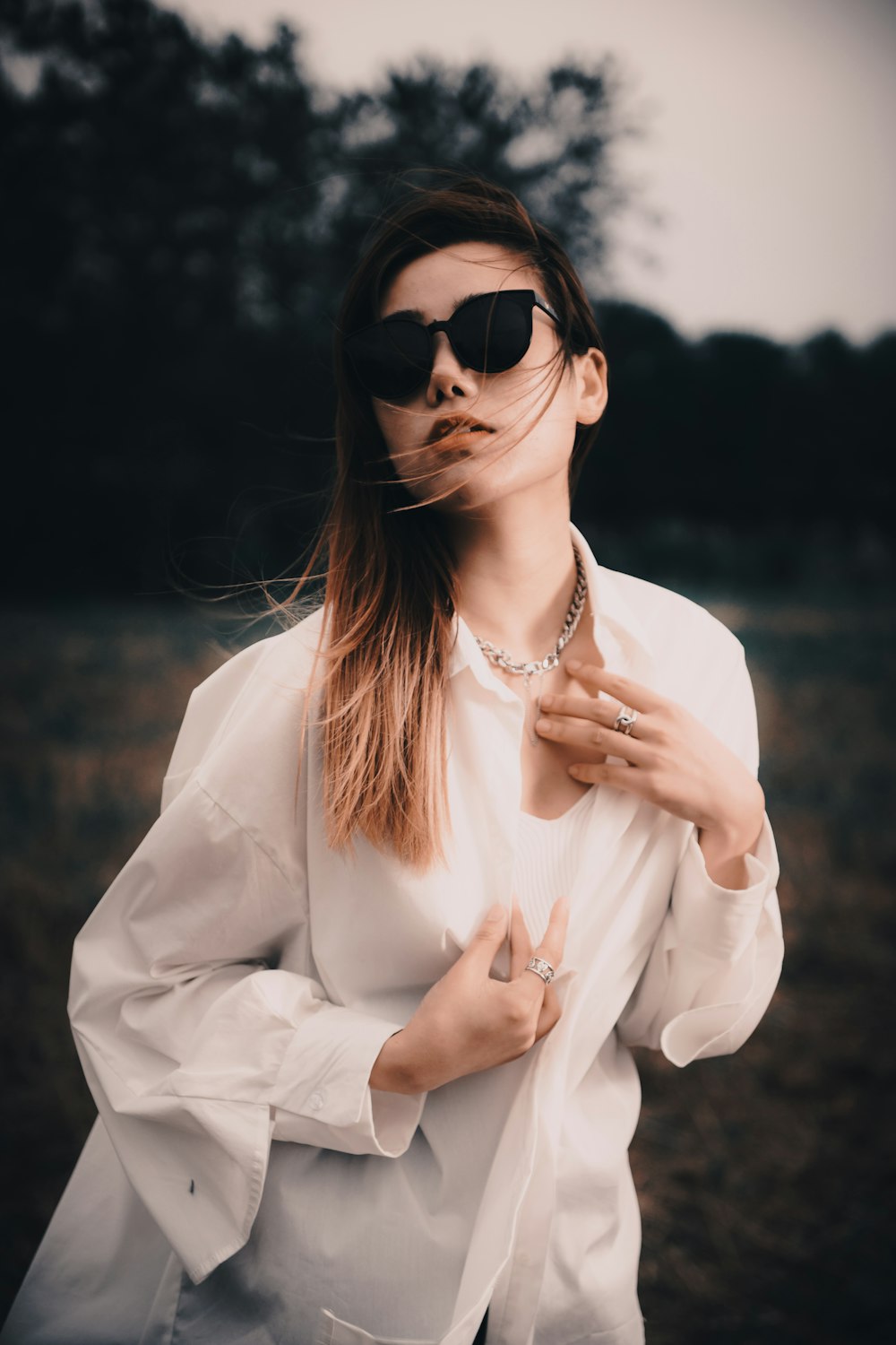 a woman wearing sunglasses and a white shirt