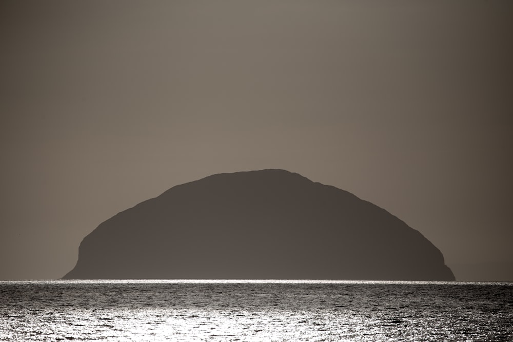 a large rock in the middle of a body of water