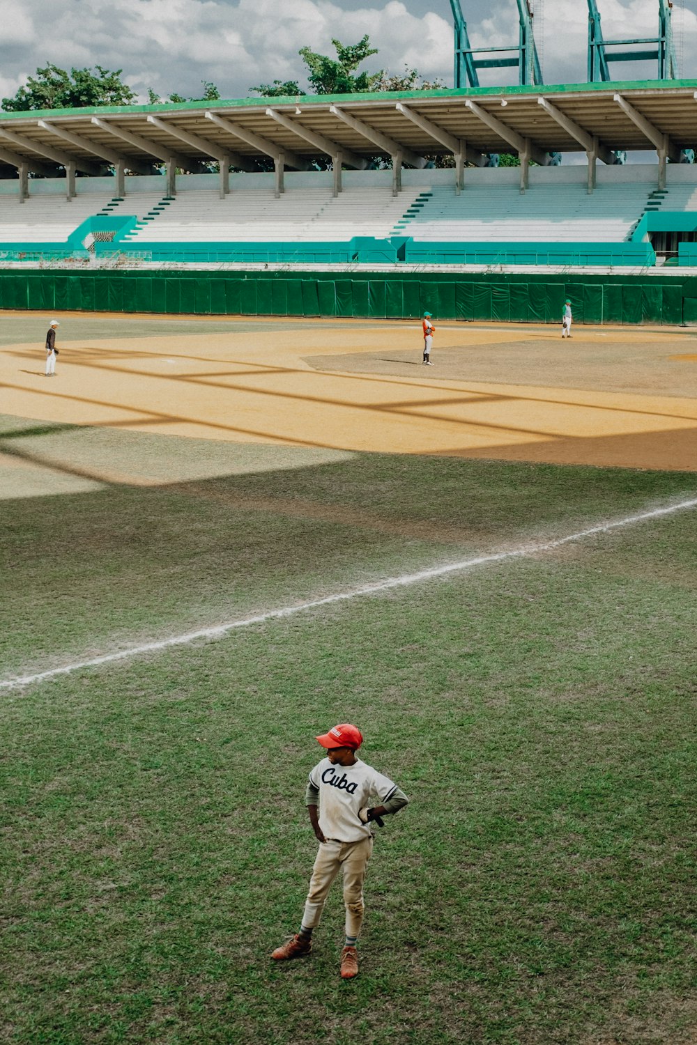 緑豊かなフィールドの上に立つ野球選手