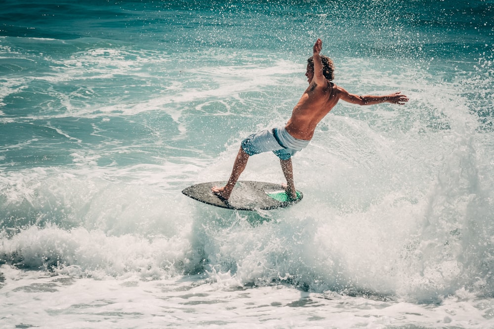 a man riding a wave on top of a surfboard