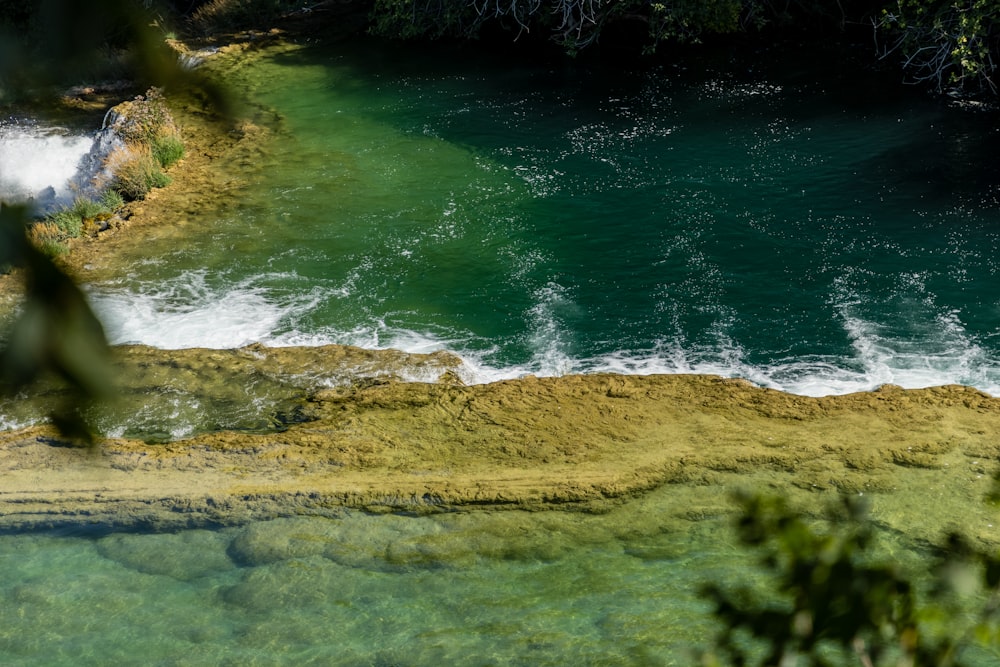 ein Gewässer mit einem Wasserfall im Hintergrund