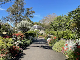 A charming garden path leading to the mansion, framed by blooming flowers.