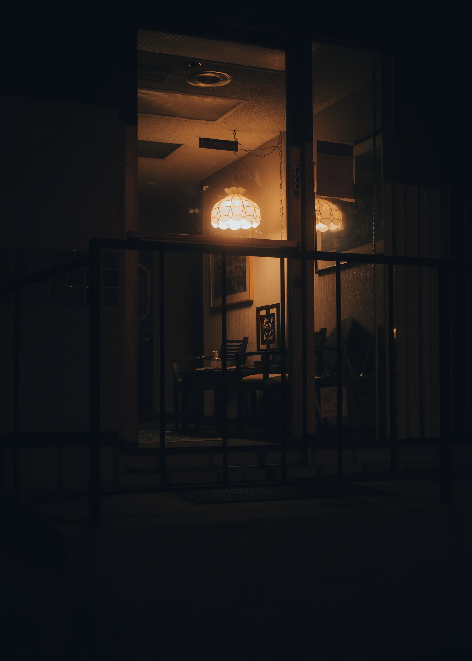 A dimly lit study room with empty tables and chairs late at night