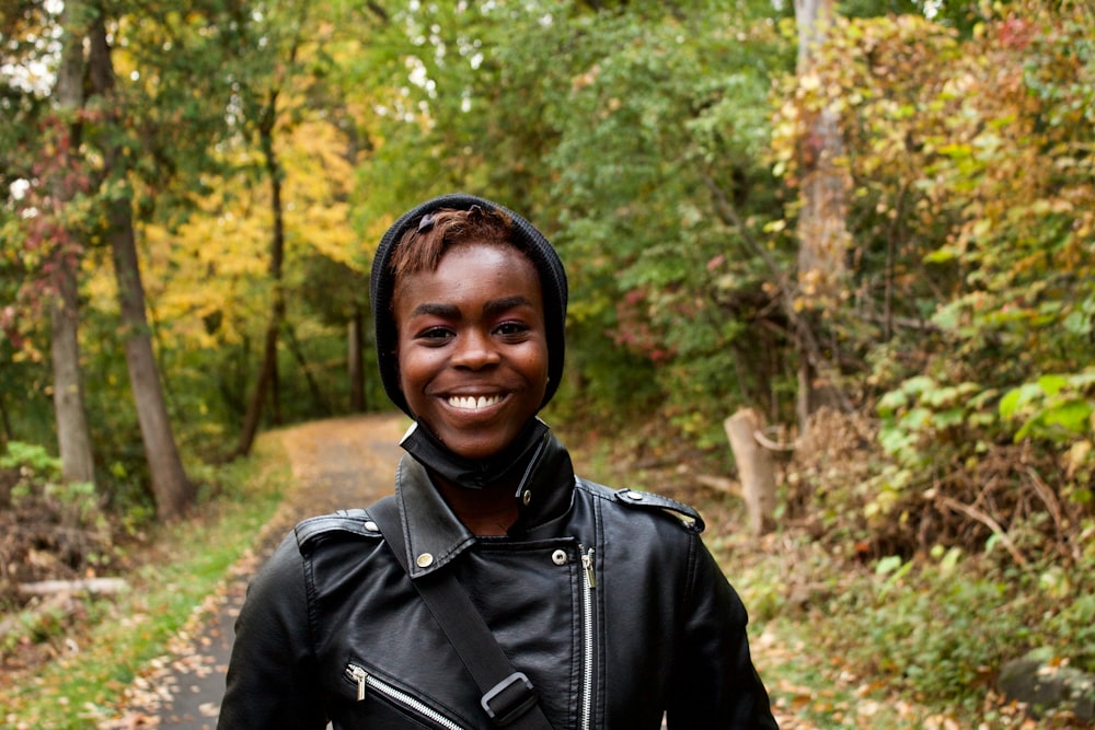 a woman wearing a black jacket and a black hoodie