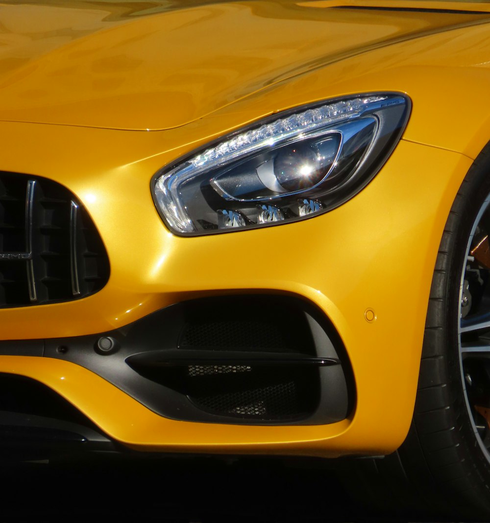 a close up of the front of a yellow sports car