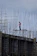 Portrait of a confident middle-aged man in a construction helmet standing on a rooftop.