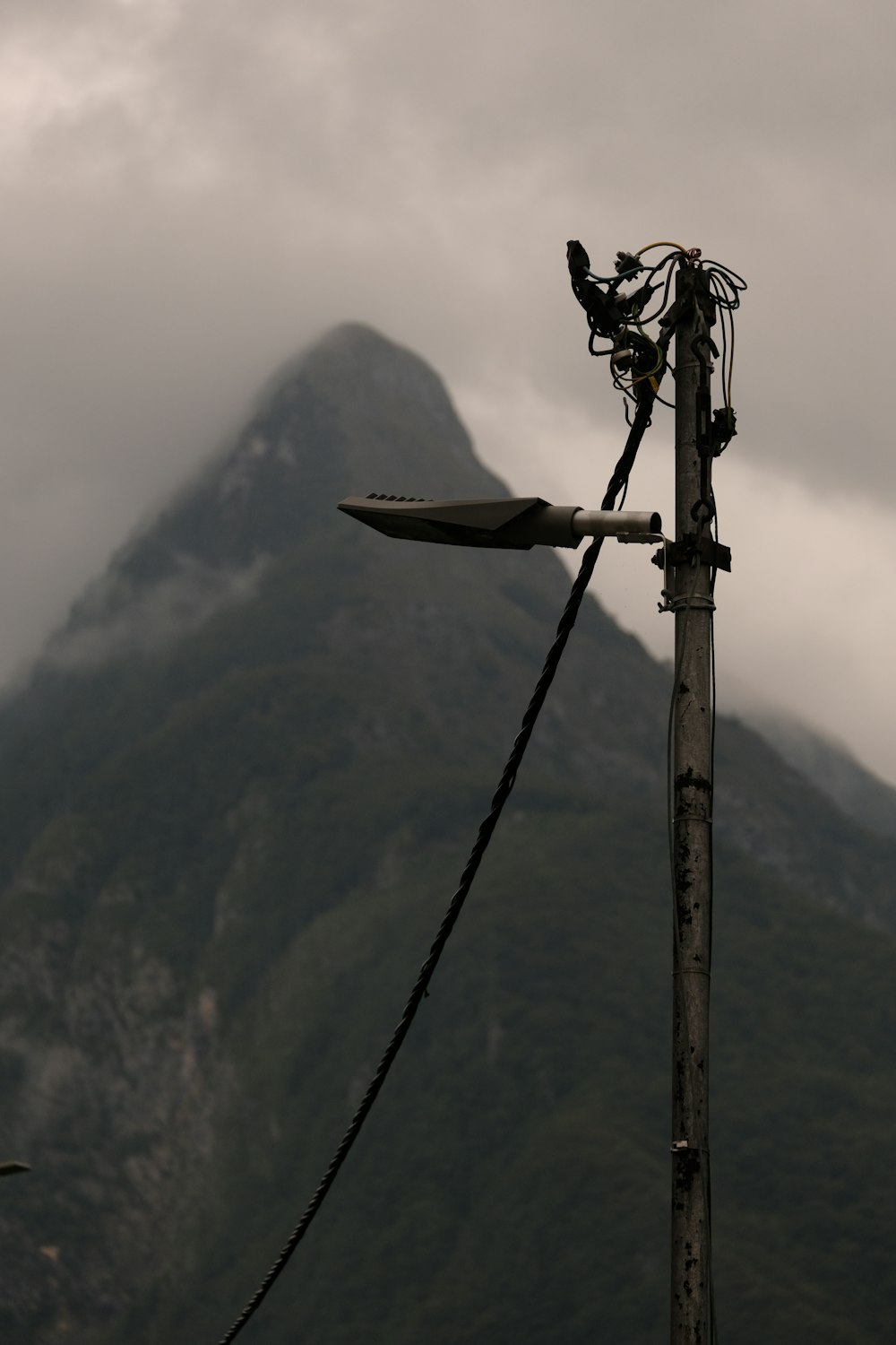 a telephone pole with a mountain in the background