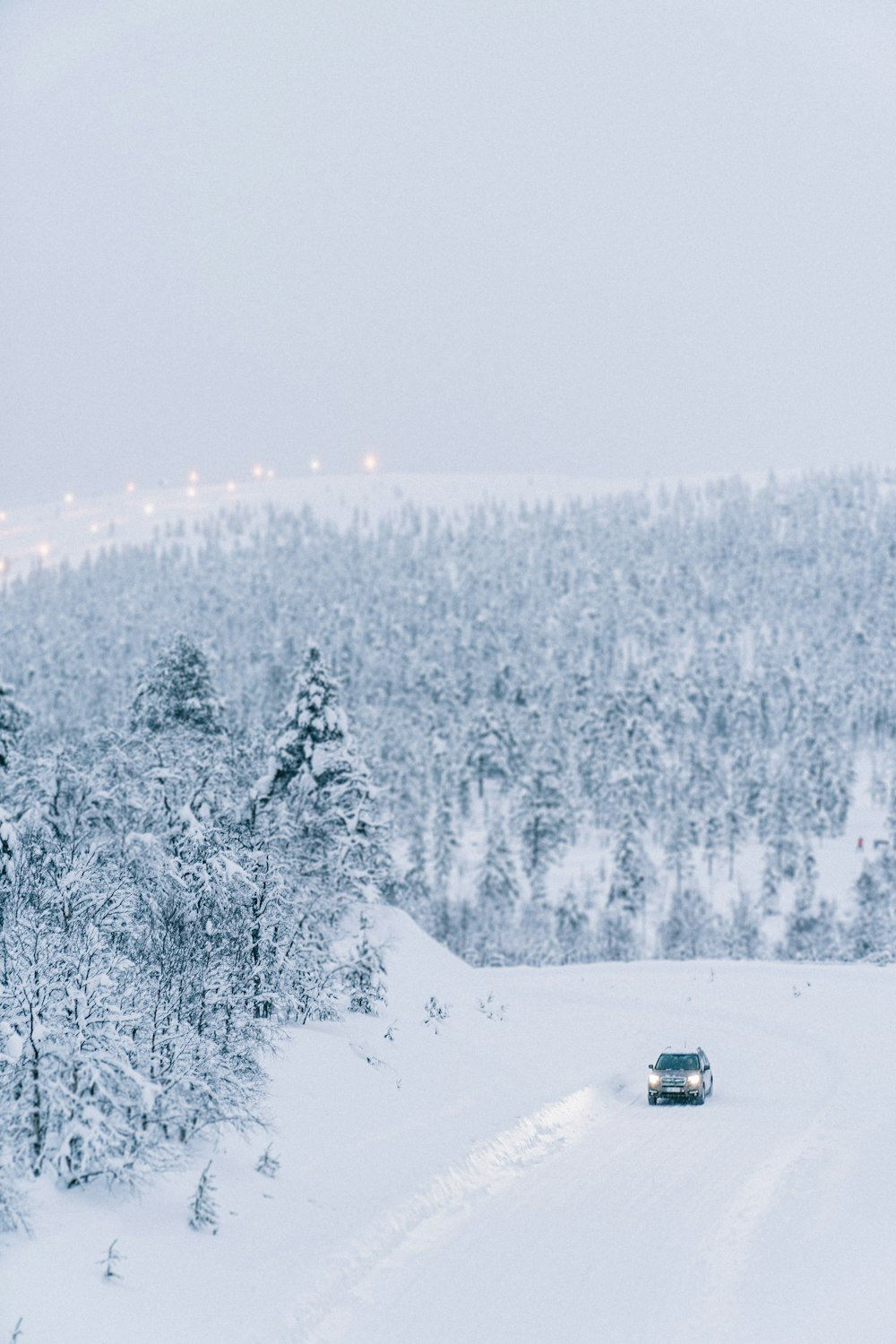 a car driving down a snow covered road