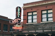 a building with a neon sign that says Leddy's boots