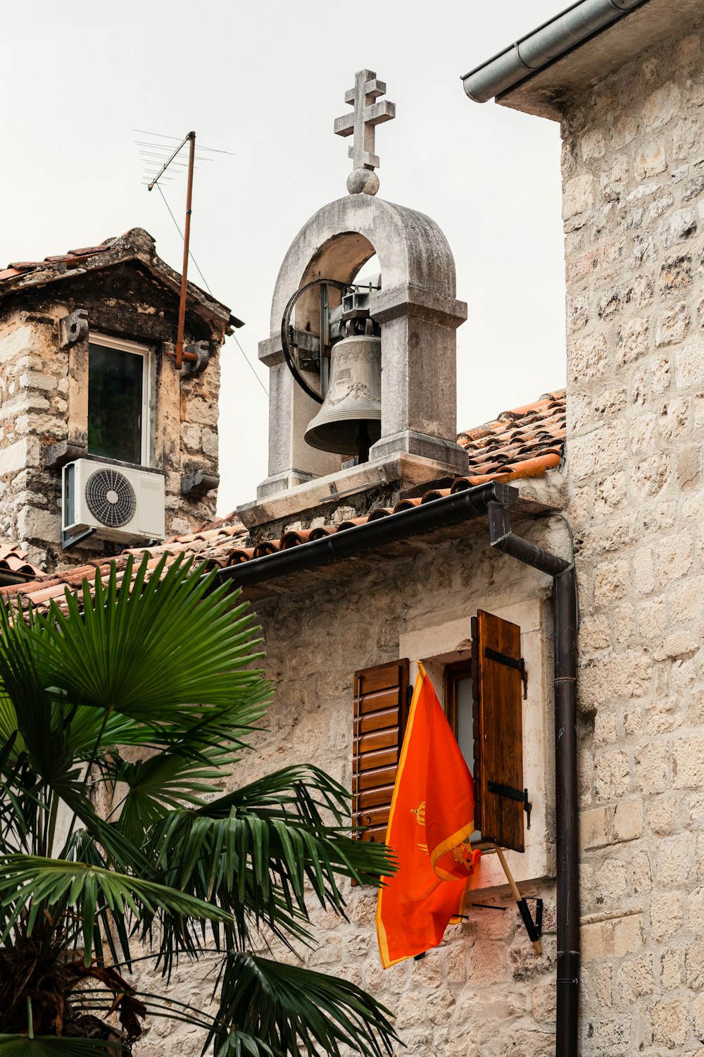 a building with a bell tower next to a palm tree