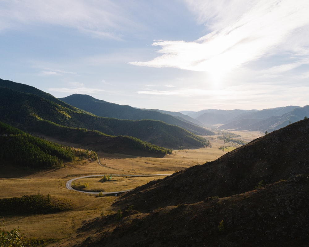 a scenic view of a winding road in the mountains