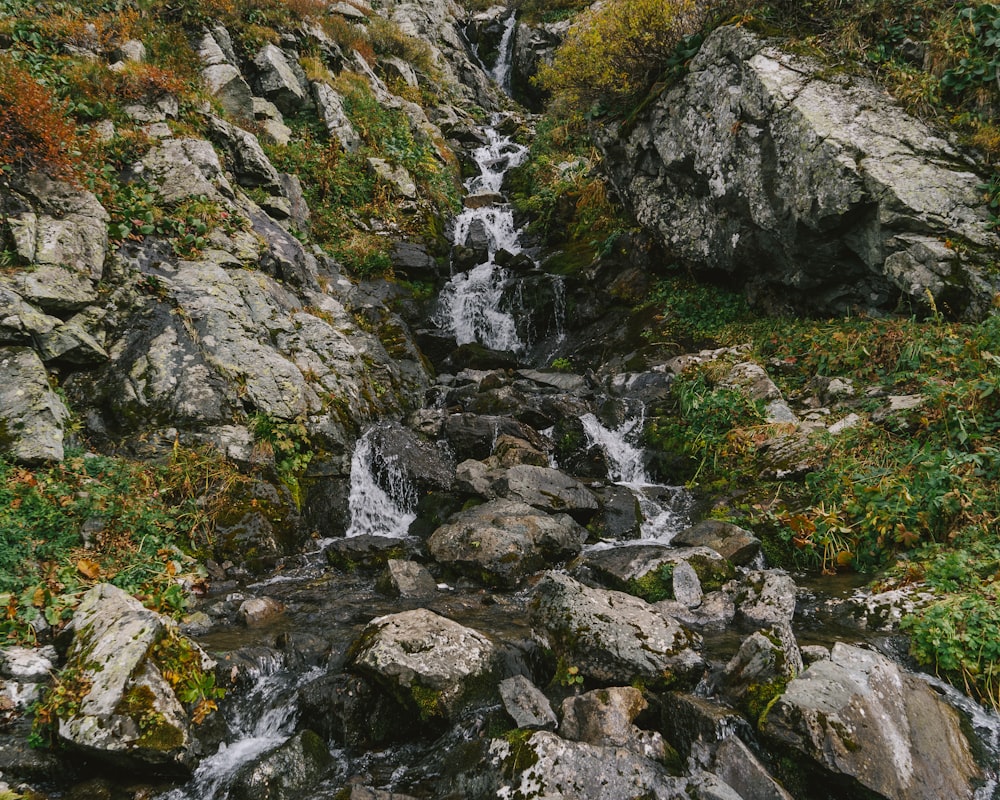 a small waterfall in the middle of a rocky area