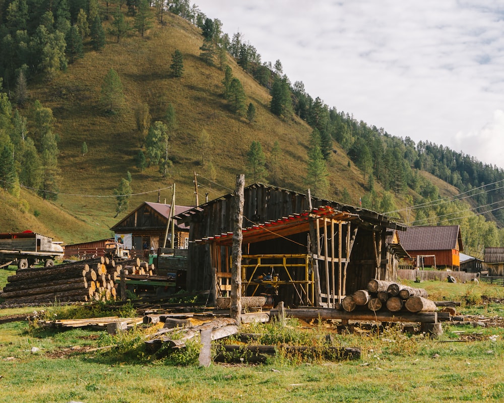 a wooden building with a pile of logs in front of it