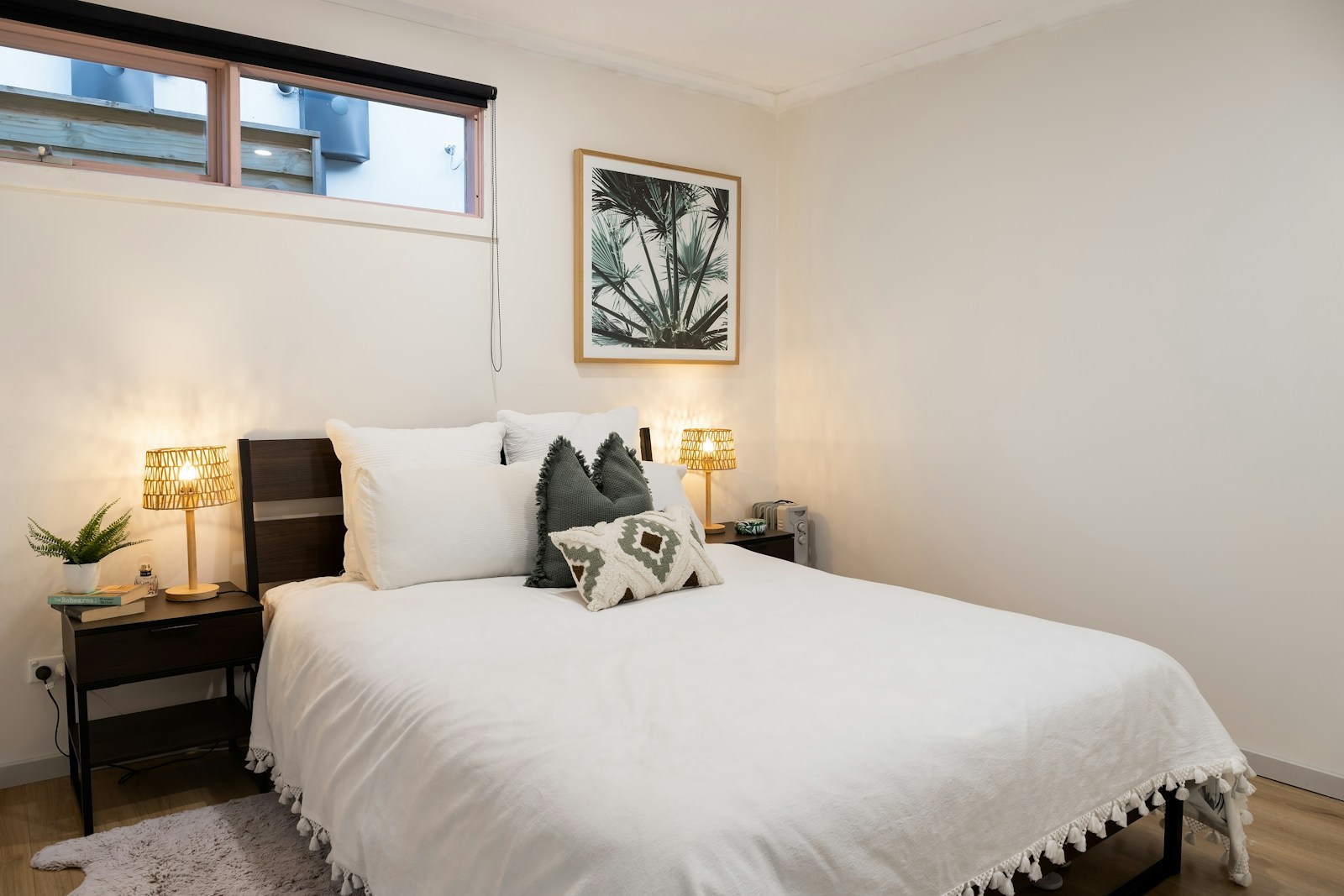 small apartment decor for single woman with white bedding palm print art and lamps