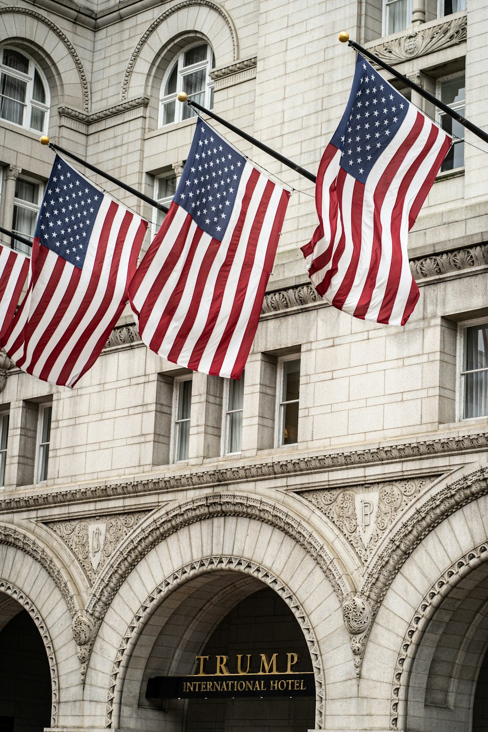 um grupo de bandeiras americanas voando em frente a um edifício