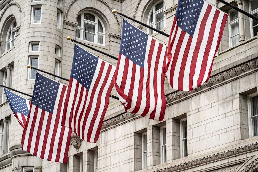 a group of american flags hanging from a street light