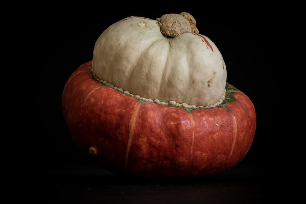 a white pumpkin sitting on top of a black surface