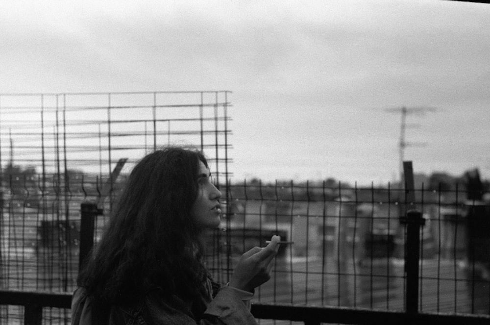 a black and white photo of a woman smoking a cigarette