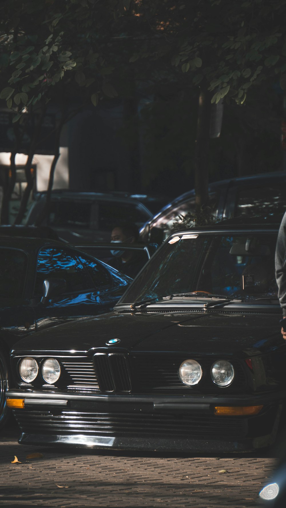 a man standing next to a parked car