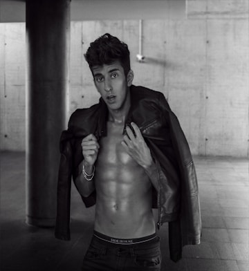 a shirtless man in a leather jacket posing for a picture