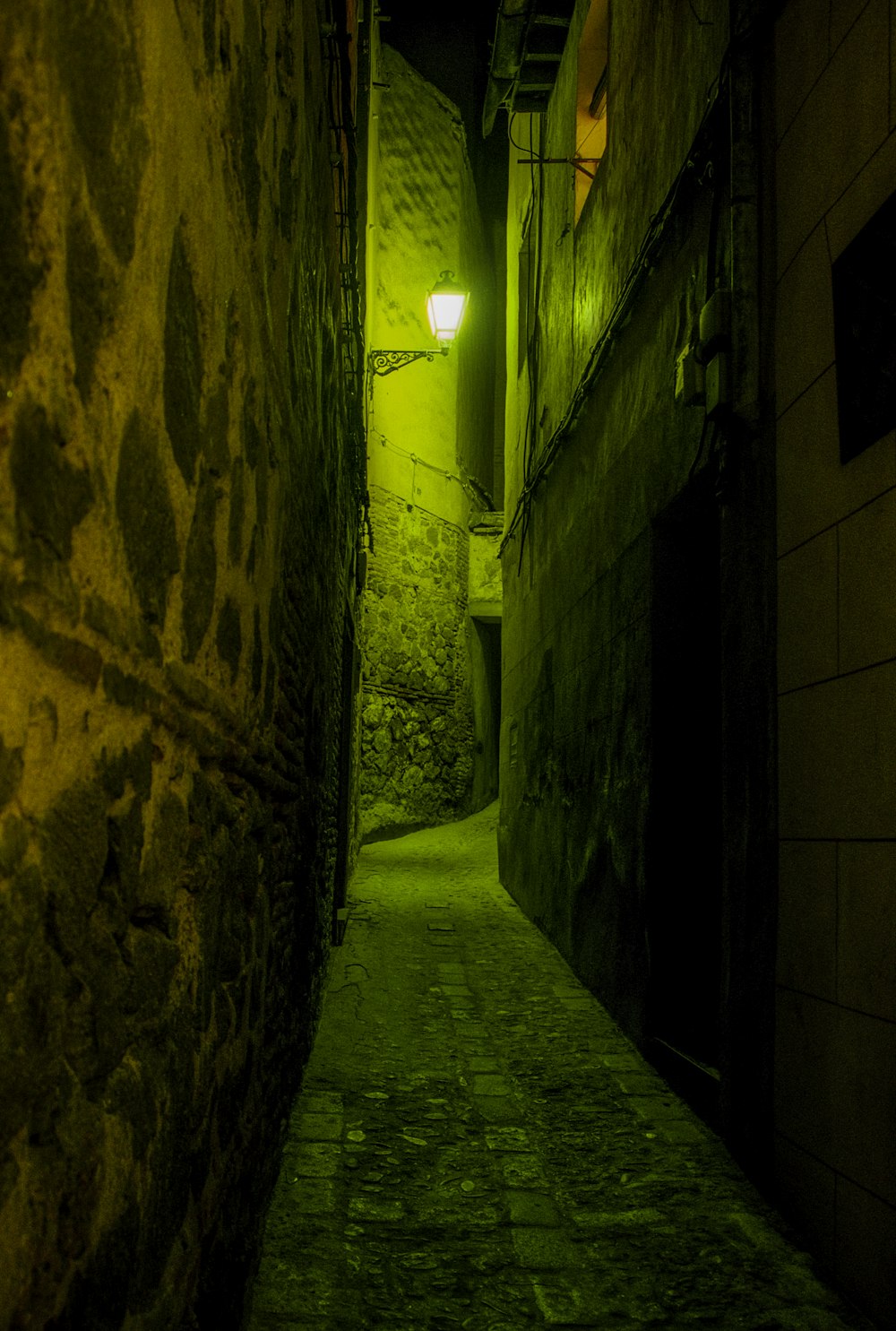 a narrow alley way with a light on