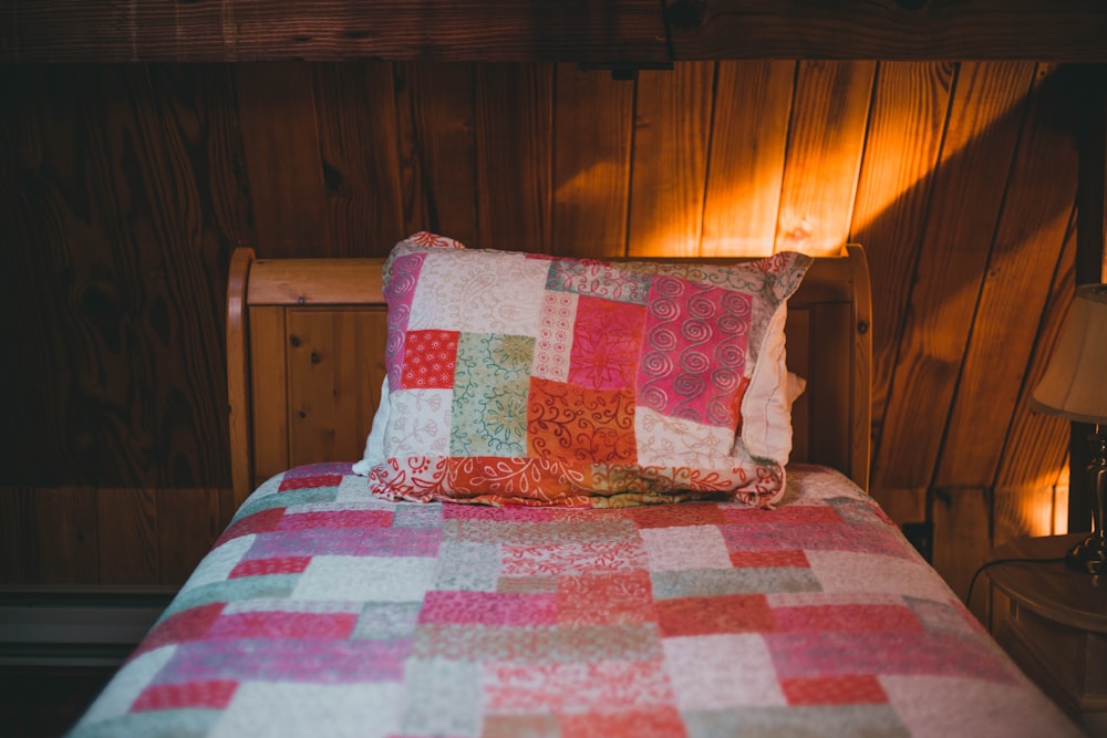 a bed with a colorful quilt on top of it