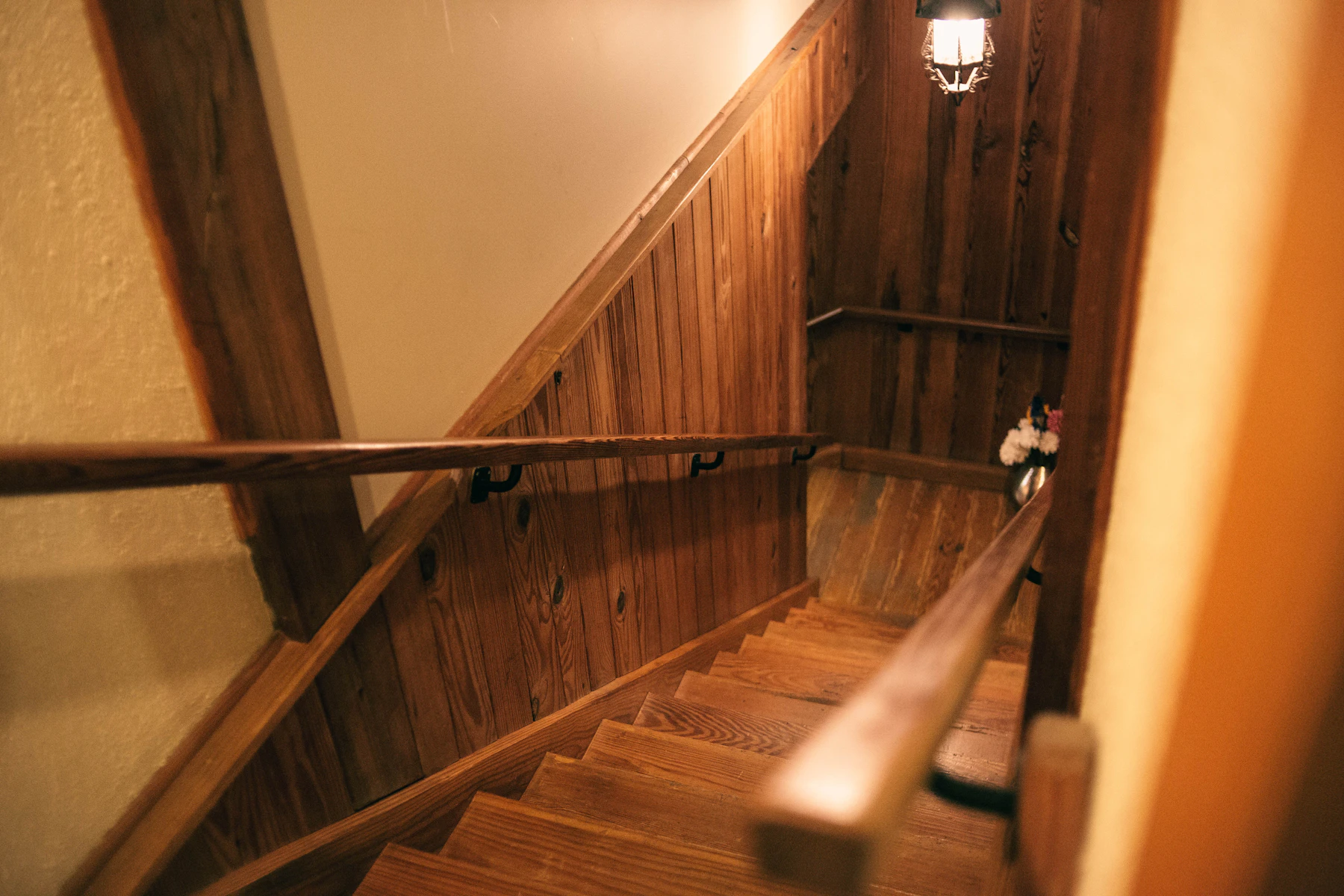 A wooden staircase between floors, a soft light from above