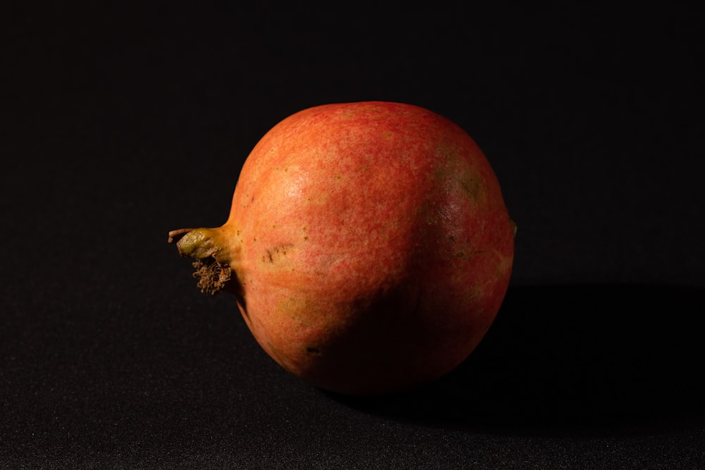 a close up of a pomegranate on a black background