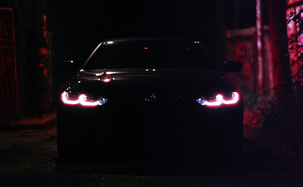 Un coche se muestra con las luces encendidas en la oscuridad
