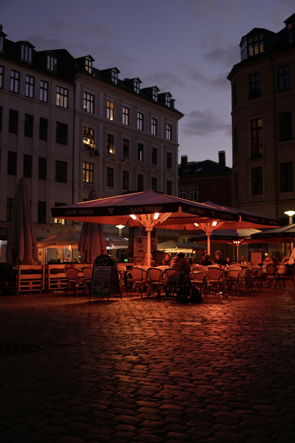 a group of people sitting at a table under an umbrella