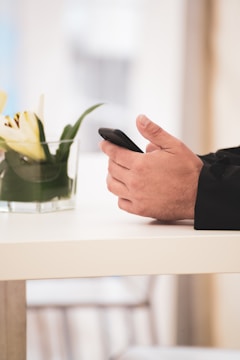 A close-up of hands typing an email on a smartphone.