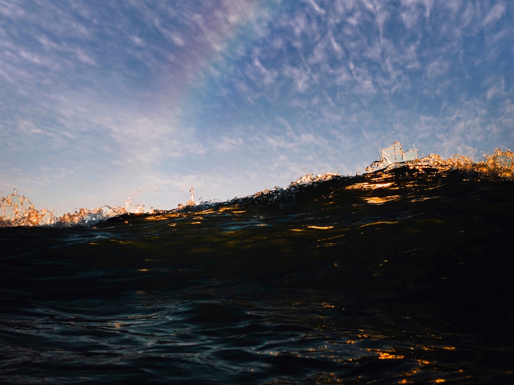 a rainbow appears in the sky over the ocean