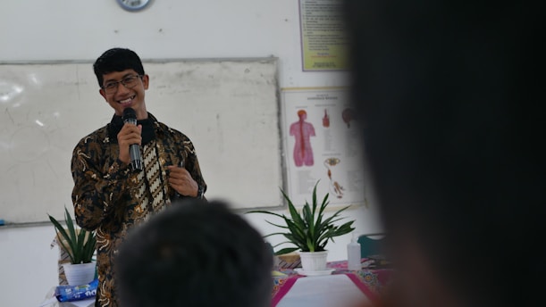 a man standing in front of a mirror holding a microphone