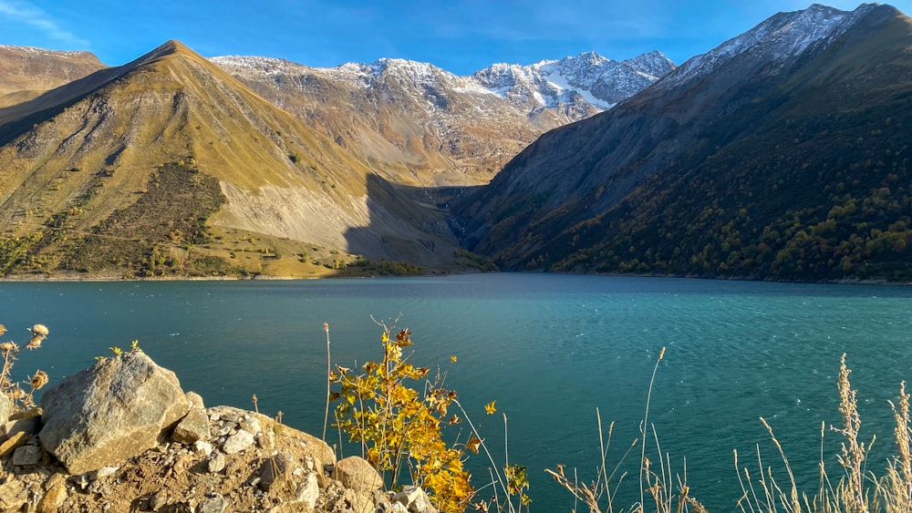 Un lago rodeado de montañas con nieve en la cima