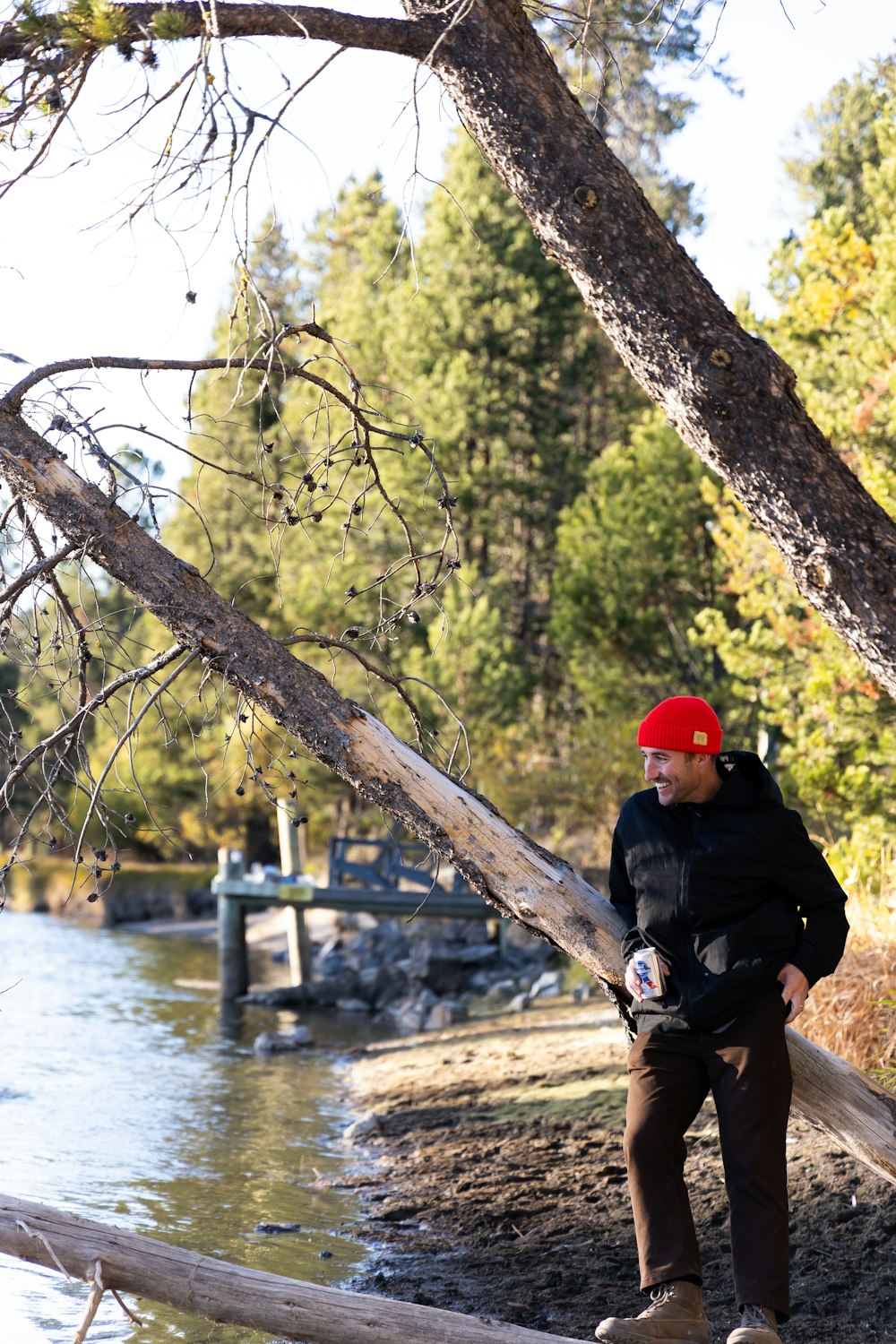 a man sitting on a log by a river