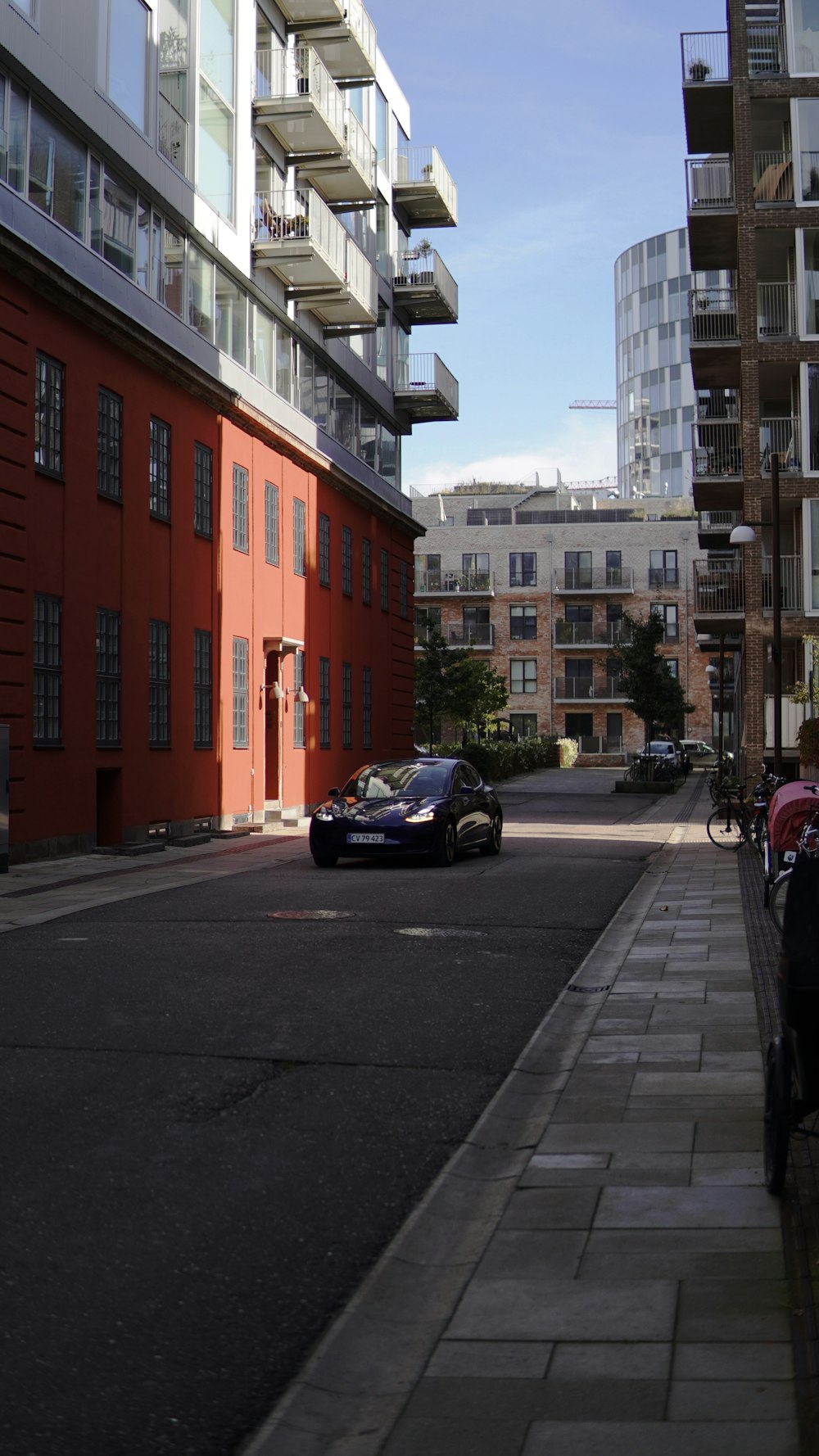 a car parked on the side of a road next to tall buildings